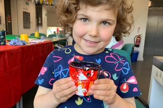 Child holding painted pot