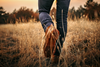 Image of legs wearing jeans and boots walking through a footpath on an arable field