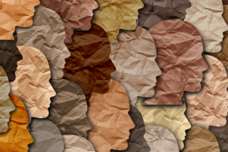 Black and brown faces cut out of paper, representing the ethnic majority