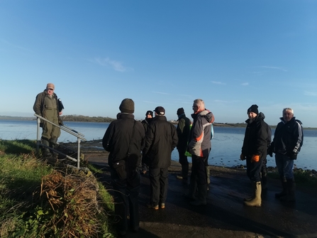 Mike Hatton talking to a group of volunteers overlooking the estuary