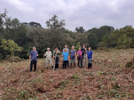 Volunteers posing for a picture with their scythes which they use to tackle the bracken at Bitchet Common