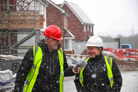 Rob Smith & Josie Cadwallader-Hughes in hard hats outside in the snow.