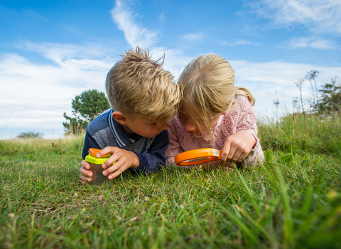 Children outdoors with magnifying glass, photo by Matthew Roberts