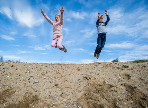 Children playing and jumping outdoors, photo by Matthew Roberts