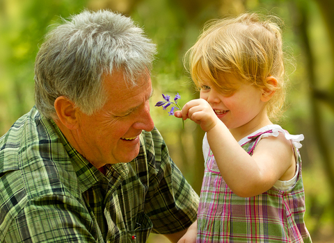 Young girl shows her granddad a bluebell, photo by Ben Hall/2020VISION