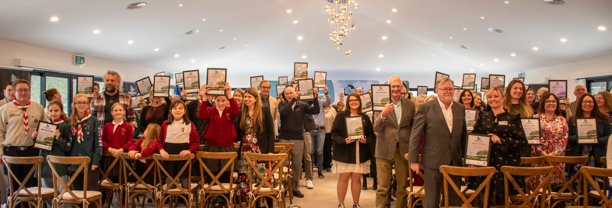 The crowd at the Wilder Kent Awards 2025 holding up their winner certificates.