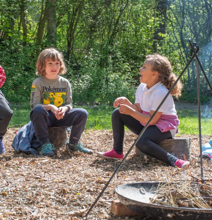 children gathered around campfire laughing