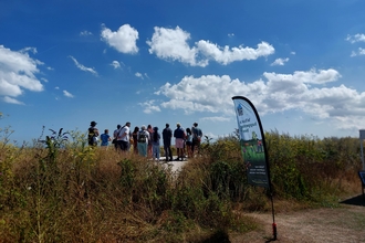 walkers on a guided walk at pegwell bay in the sun