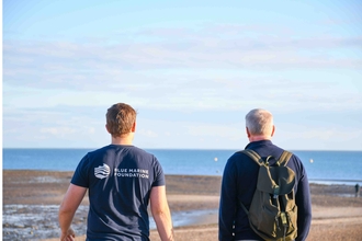 Matt Uttley from Blue Marine Foundation and Rob Smith, host of the Talk on the Wild Side podcast, facing away from the camera and looking towards the sea at brightlingsea