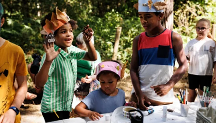 Three children crafting outside in the sunshine