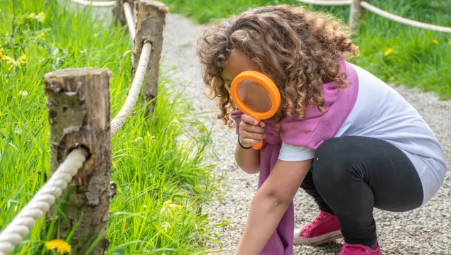 girl looking through magnifier 