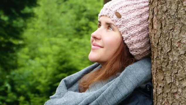 Woman sitting against a tree