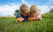 Children outdoors with magnifying glass, photo by Matthew Roberts