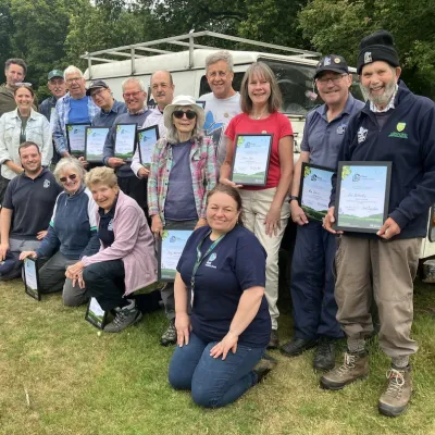 A group of Ashford Kent Wildlife Trust volunteers standing with their Wilder Kent Award certificates.
