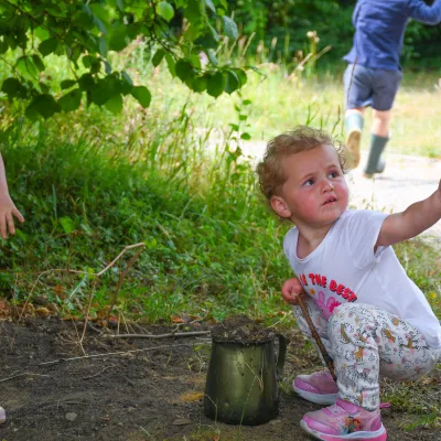 Nature tots toddler playing and looking up at parent