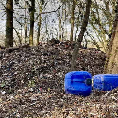 Hoad's wood fly tipping pile with blue plastic containers in foreground