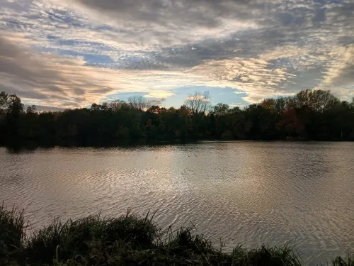Aview over the lakes at Sevenoaks Wildlife Reserve, with a sunset.