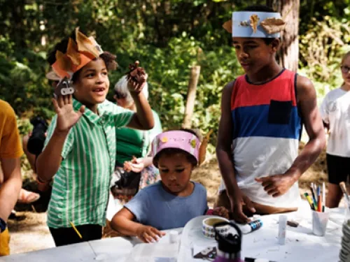 Three children crafting outside in the sunshine