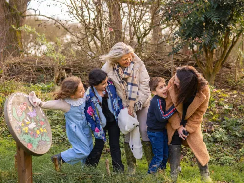 Women and three children laughing outdoors