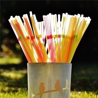 Metal container holding plastic drinking straws