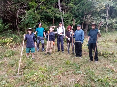 Group of 7 volunteers standing with tools