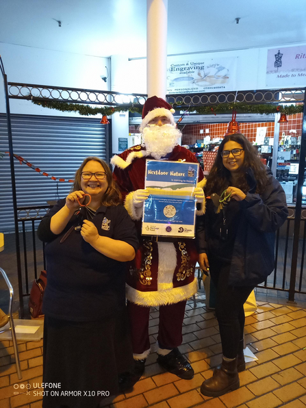 nextdoor nature project officers posing for a photo with santa in a shopping centre