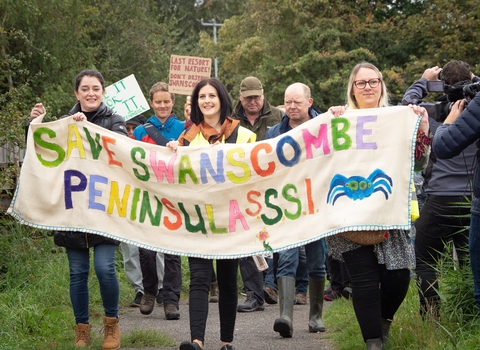 People at Save Swanscombe rally holding banner which reads "Save Swanscombe Peninsula SSSI"
